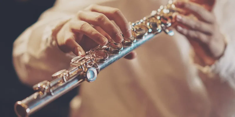 Photo of a close up of a person playing a flute