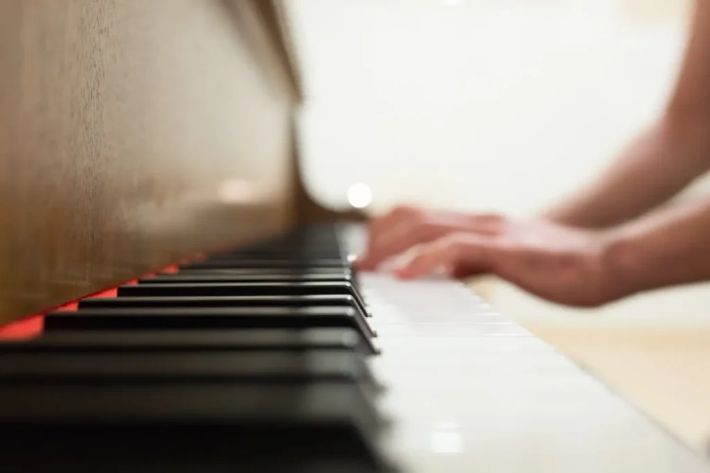 Close up photo of piano keys being played by out of focus hands. Fractional pedaling.