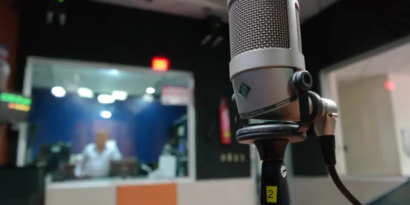 Photo of a microphone in a recording studio, with a blurry background